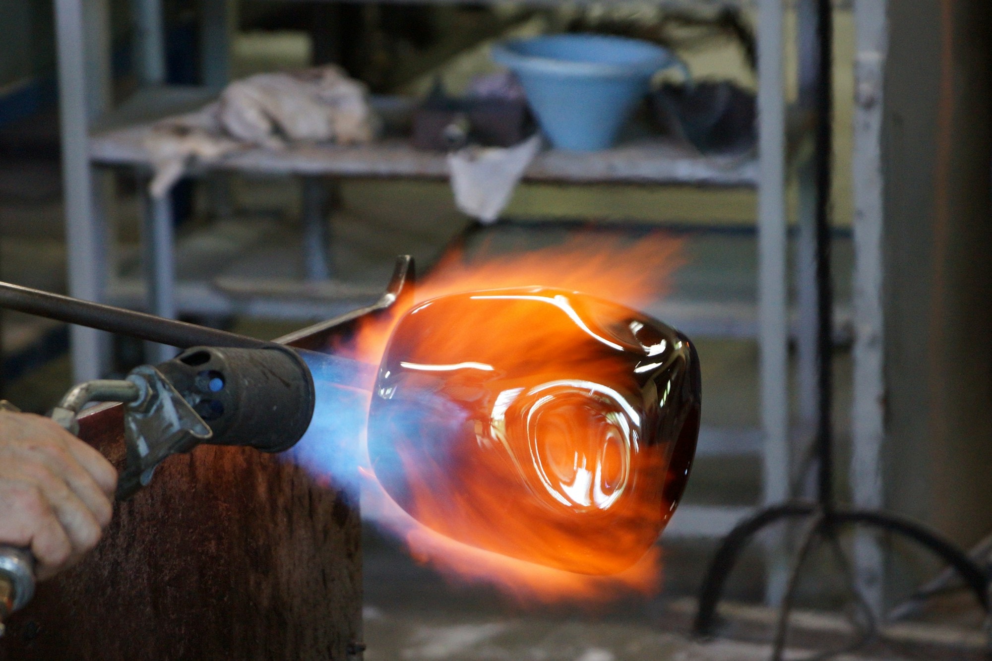 Artigiano al lavoro sul vetro soffiato con la fiamma